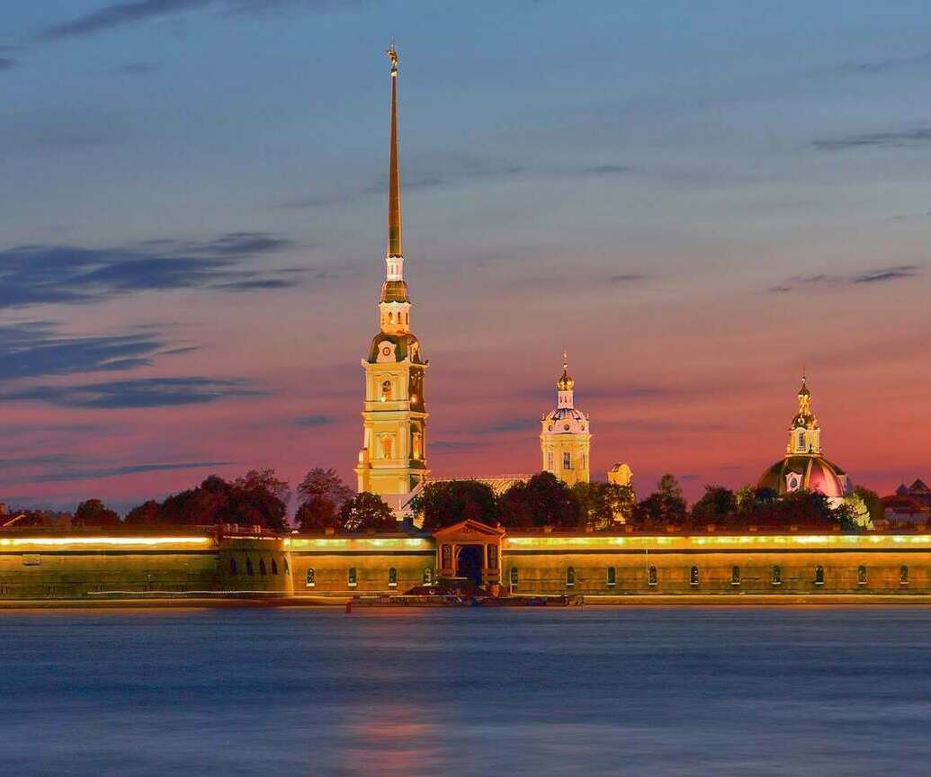 Peter and Paul Fortress in St. Petersburg at sunset, with historic fortifications illuminated by warm evening light