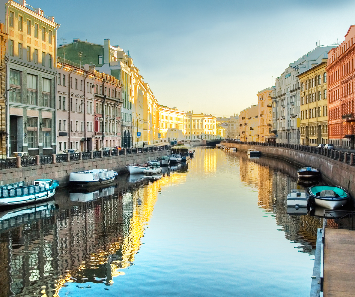 Sightseeing boats cruising along a scenic canal in St. Petersburg, surrounded by historic buildings