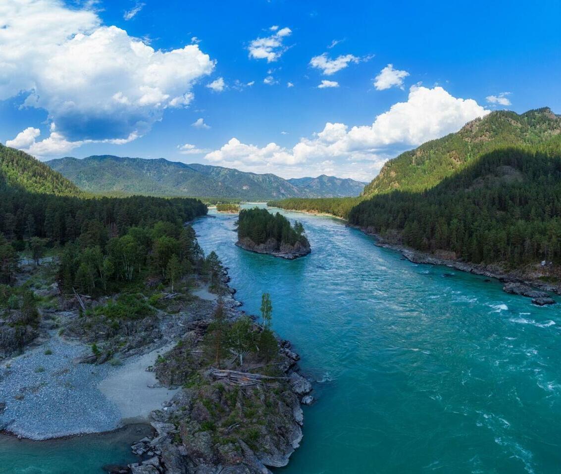Aerial panorama of the turquoise Katun River flowing through the Altai Mountains. One of the most iconic natural attractions in Siberia and a must-see destination in Russia.