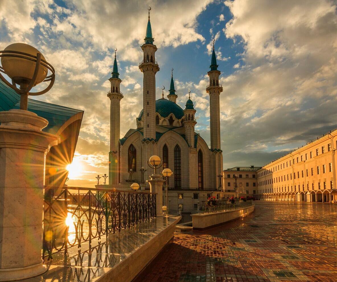 Kul Sharif Mosque in Kazan glowing in warm sunlight, with its blue dome and elegant white minarets