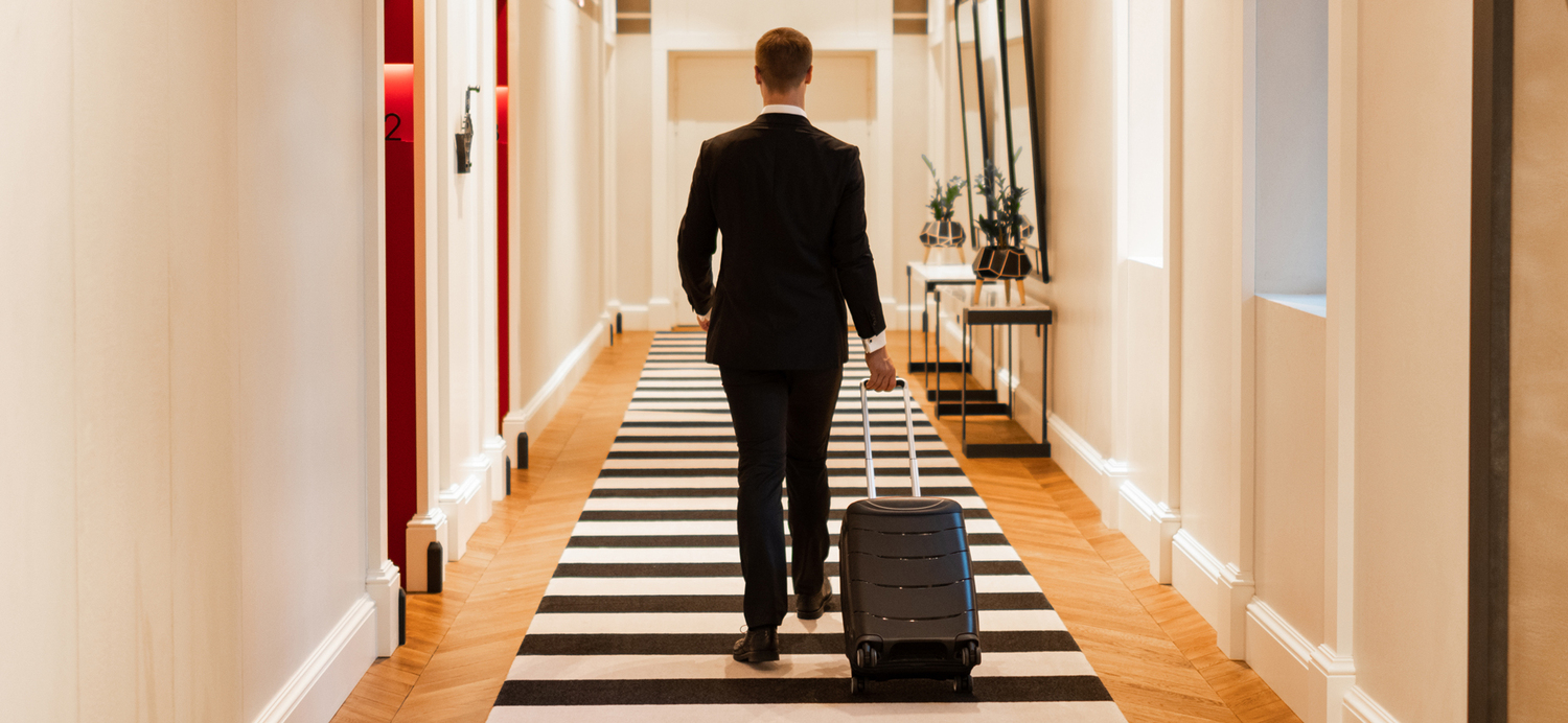 Traveler with suitcase walking through a hotel corridor in Russia during check-in